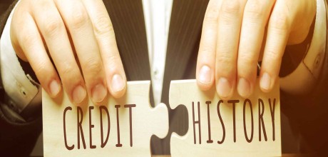 A man holding two connecting jigsaw pieces that say credit and history