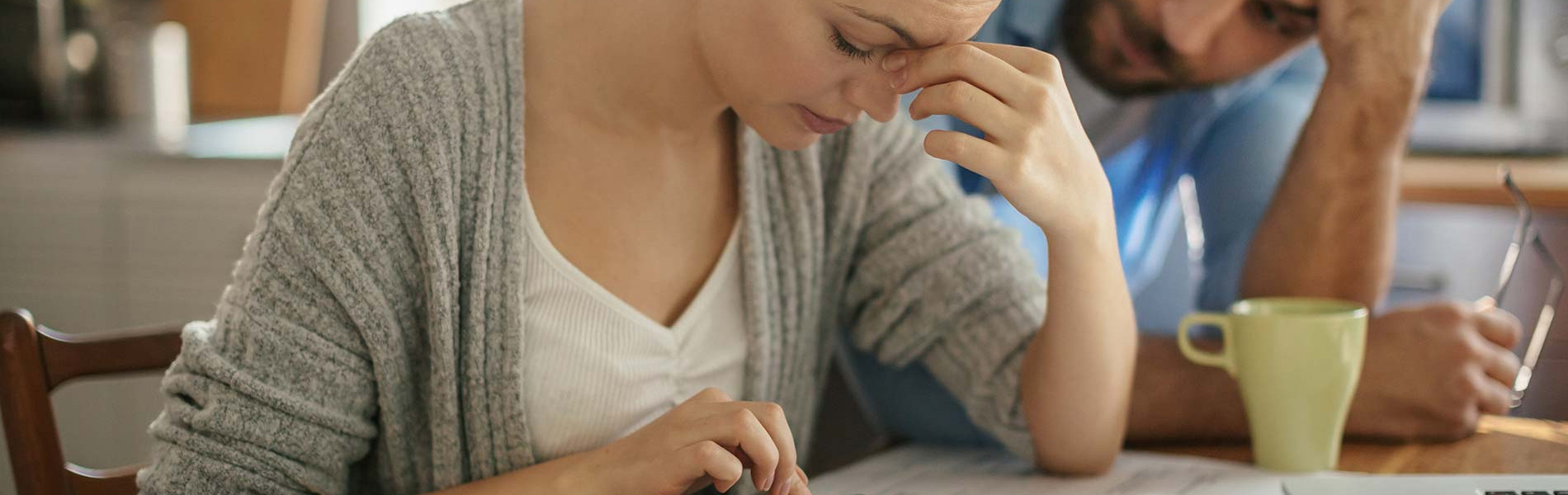 A couple appearing stressed at a kitchen table