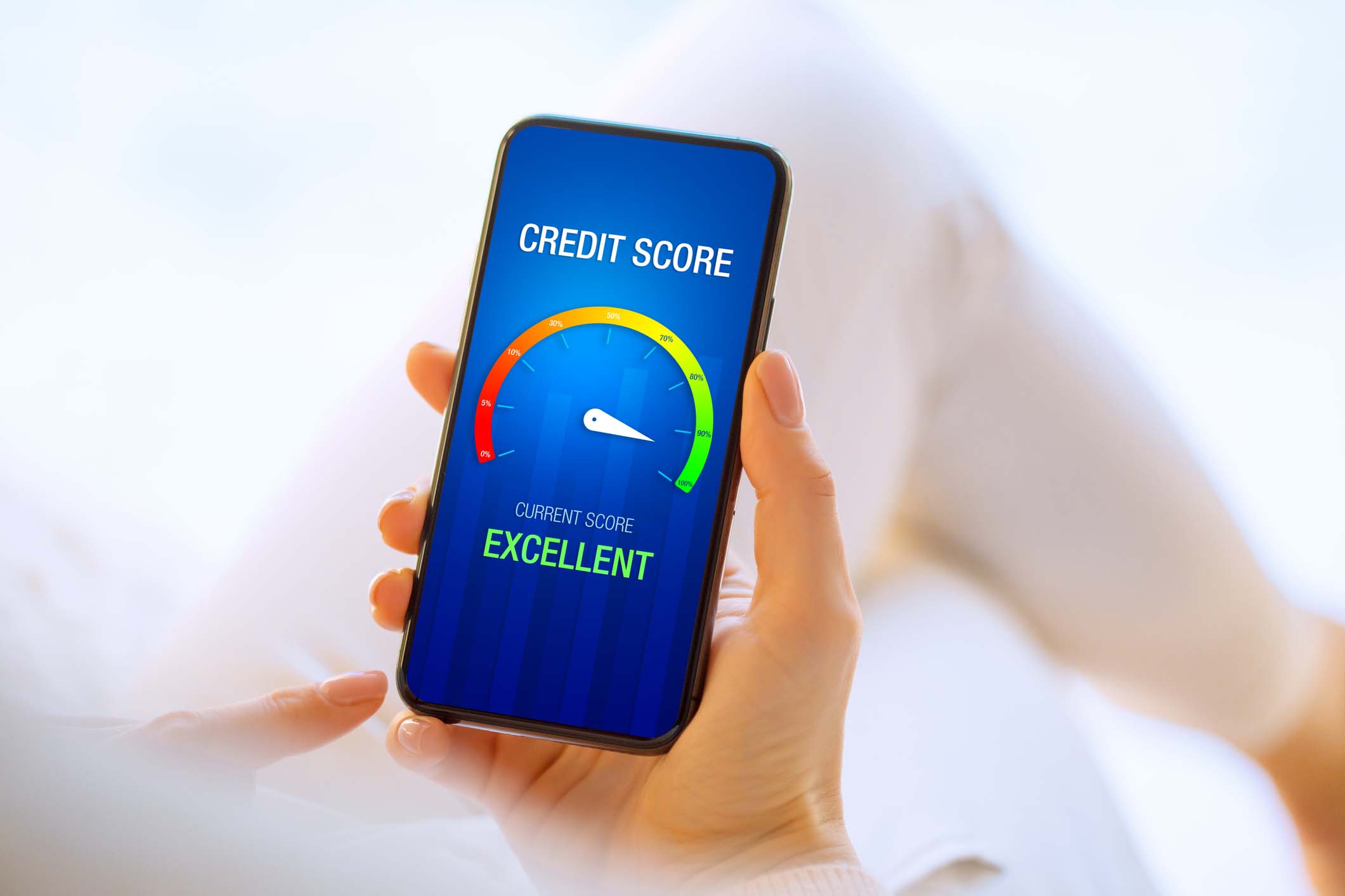 A person holding their phone showing an excellent credit score on the screen