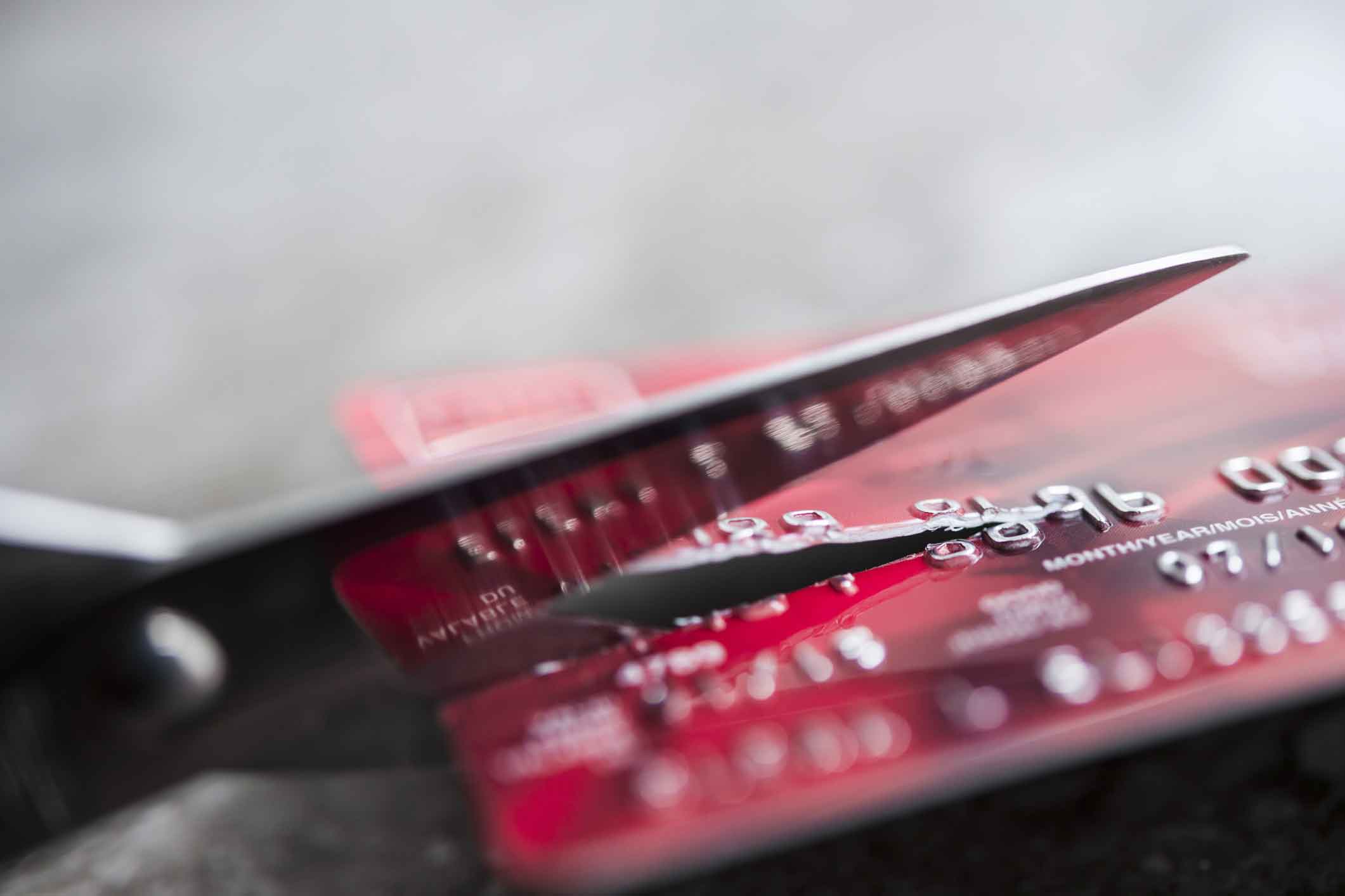 A scissors cutting a credit card in half