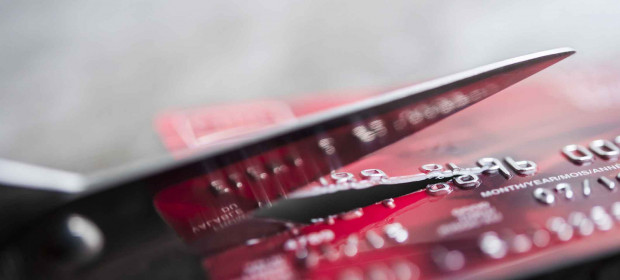 A scissors cutting a credit card in half