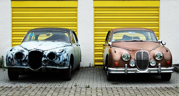 An old blue car next to a new brown car